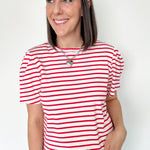Red and white horizontal striped top. High round neckline with short sleeves. Regular fit. Slight puff in the sleeves.