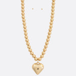 Photo of a beaded metal necklace with a heart charm 