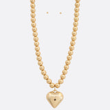 Photo of a beaded metal necklace with a heart charm 