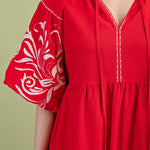 Poppy colored dress. Collared. Tiered detailing. Hits above the knee. Pattern on the short sleeves in white.