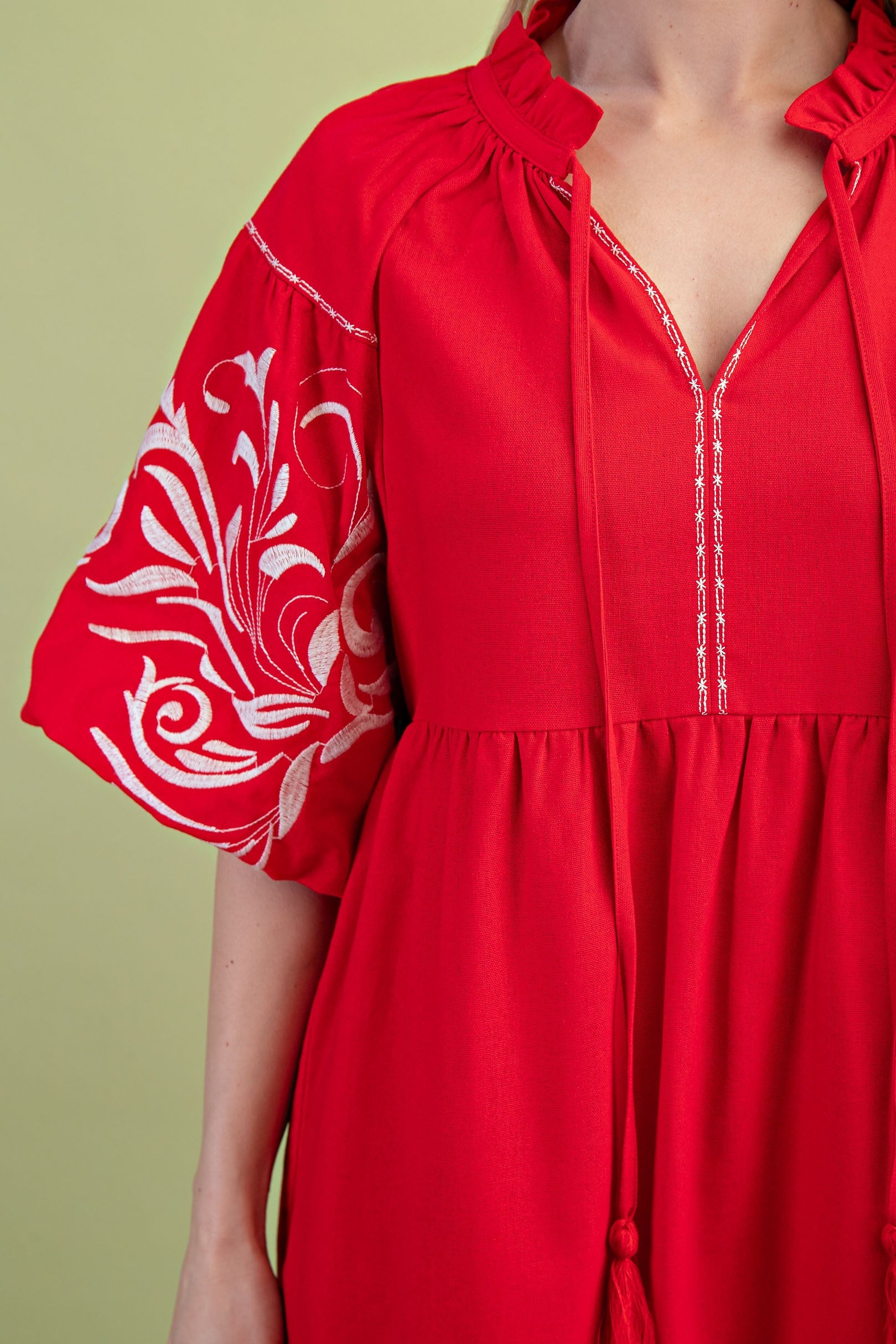 Poppy colored dress. Collared. Tiered detailing. Hits above the knee. Pattern on the short sleeves in white.