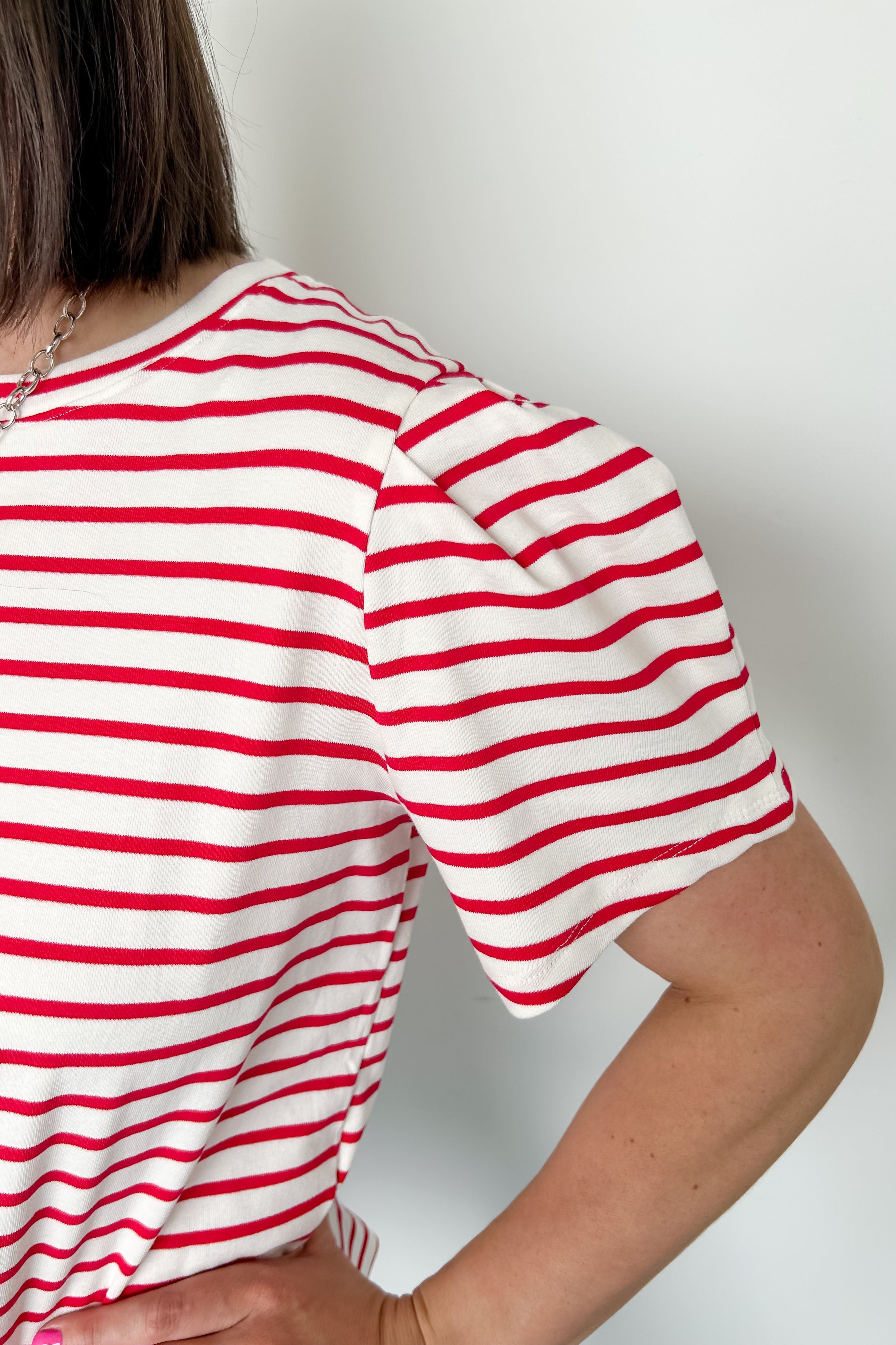 Red and white horizontal striped top. High round neckline with short sleeves. Regular fit. Slight puff in the sleeves.