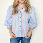 Collared light blue top with pink pin stripes with a touch of white. Button up style. Loose fit. 3/4 length sleeves that have a slight puff look to them.