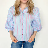 Collared light blue top with pink pin stripes with a touch of white. Button up style. Loose fit. 3/4 length sleeves that have a slight puff look to them.