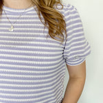 Striped high round neck top. Short sleeve. Regular fit. Slightly puffed sleeves. White and light purple in color.