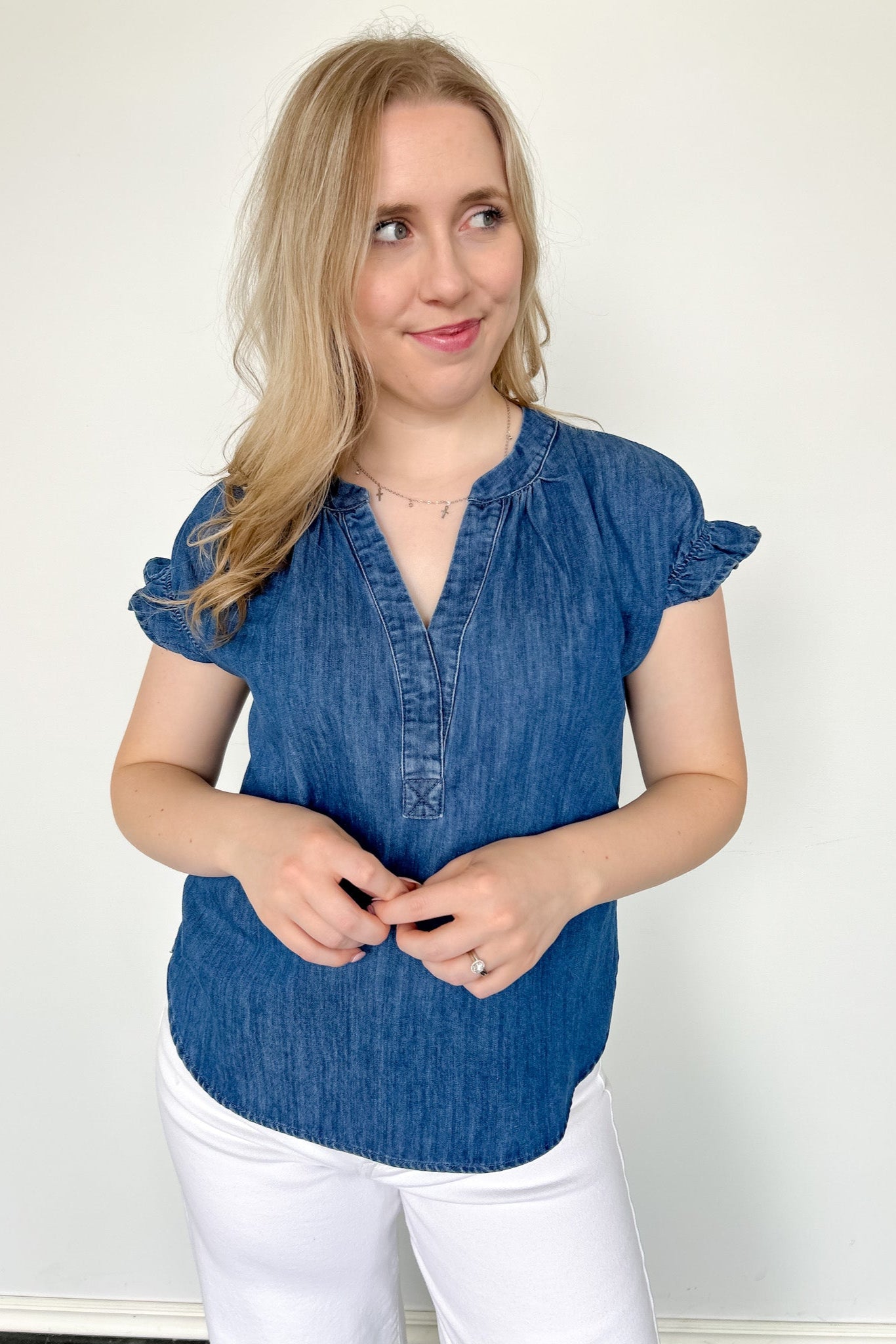 Denim top with slight v neckline and ruffled sleeves. Regular fit. Medium denim in color. Short sleeve. 