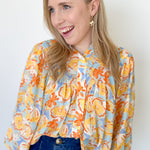 Photo of model wearing an orange and yellow floral blouse