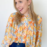 Photo of model wearing an orange and yellow floral blouse