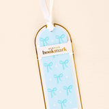 Acrylic bookmark with bow design in packaging on a beige background