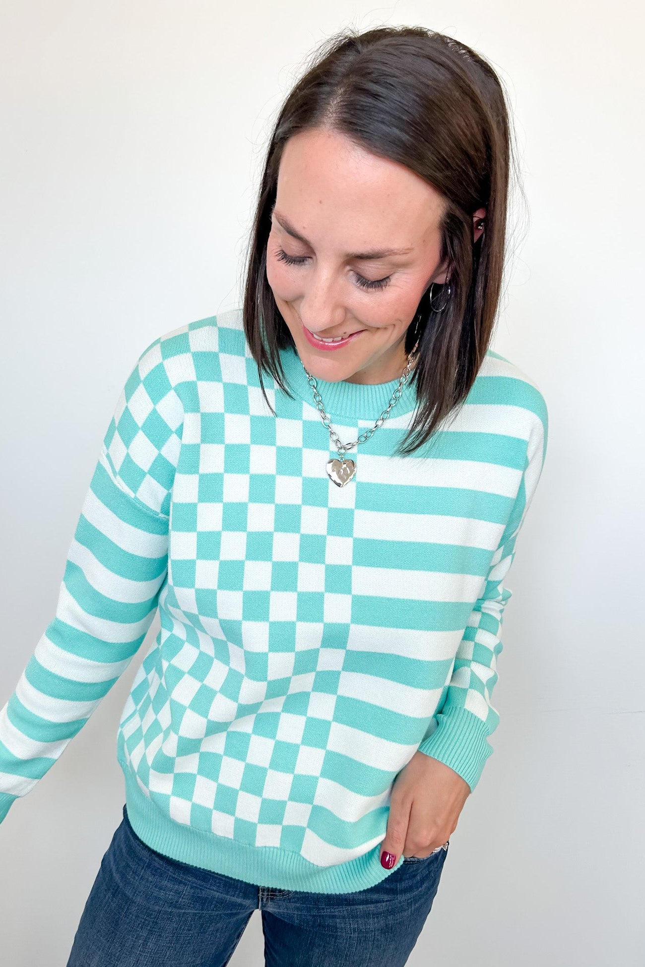 Woman wearing a checkered sweater with a white background