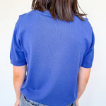 Person wearing a blue textured shirt against a white background