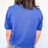 Person wearing a blue textured shirt against a white background