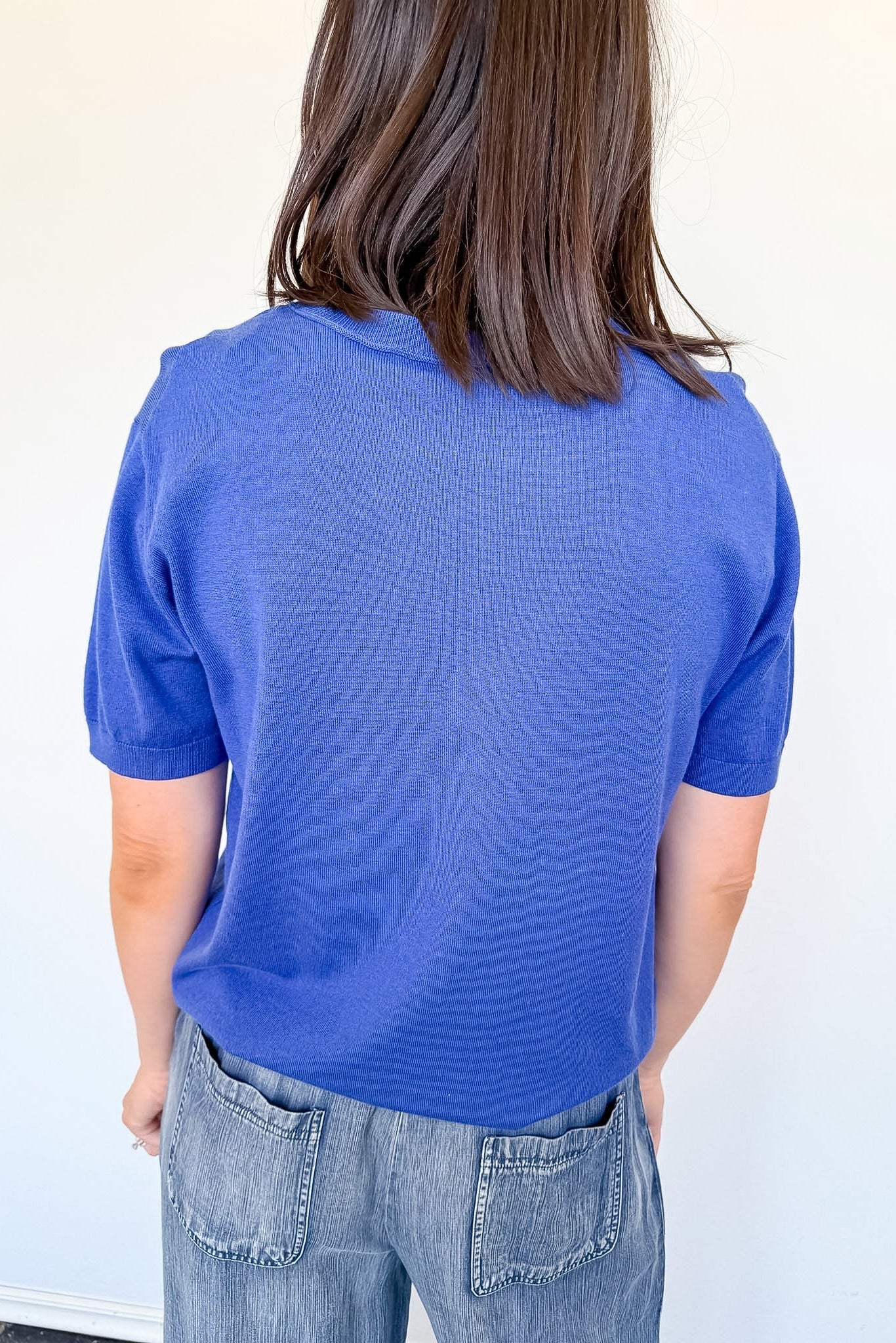 Person wearing a blue textured shirt against a white background