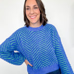 Woman wearing a blue and green patterned sweater against a white background