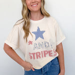 Woman wearing a white t-shirt with a star design and text, standing against a plain background