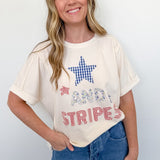 Woman wearing a white t-shirt with a star design and text, standing against a plain background