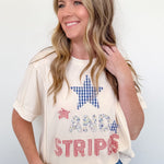 Woman wearing a graphic t-shirt with a star and text design on a plain background