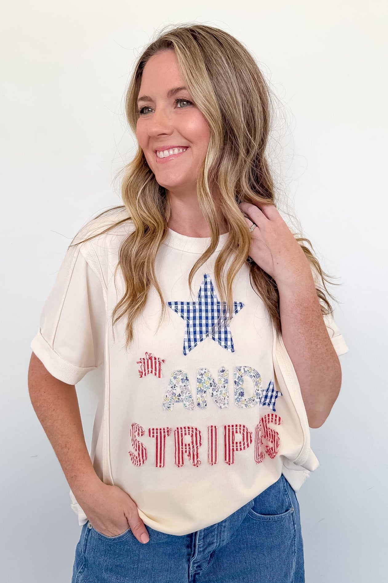 Woman wearing a graphic t-shirt with a star and text design on a plain background
