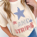 Person wearing a cream-colored t-shirt with a star and text design, standing against a white background.