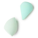 Two light green makeup sponges on a white background