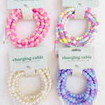 Four charging cable protectors with colorful beads on a white background