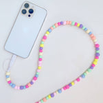 Colorful beaded phone lanyard with a smartphone on a light gray background