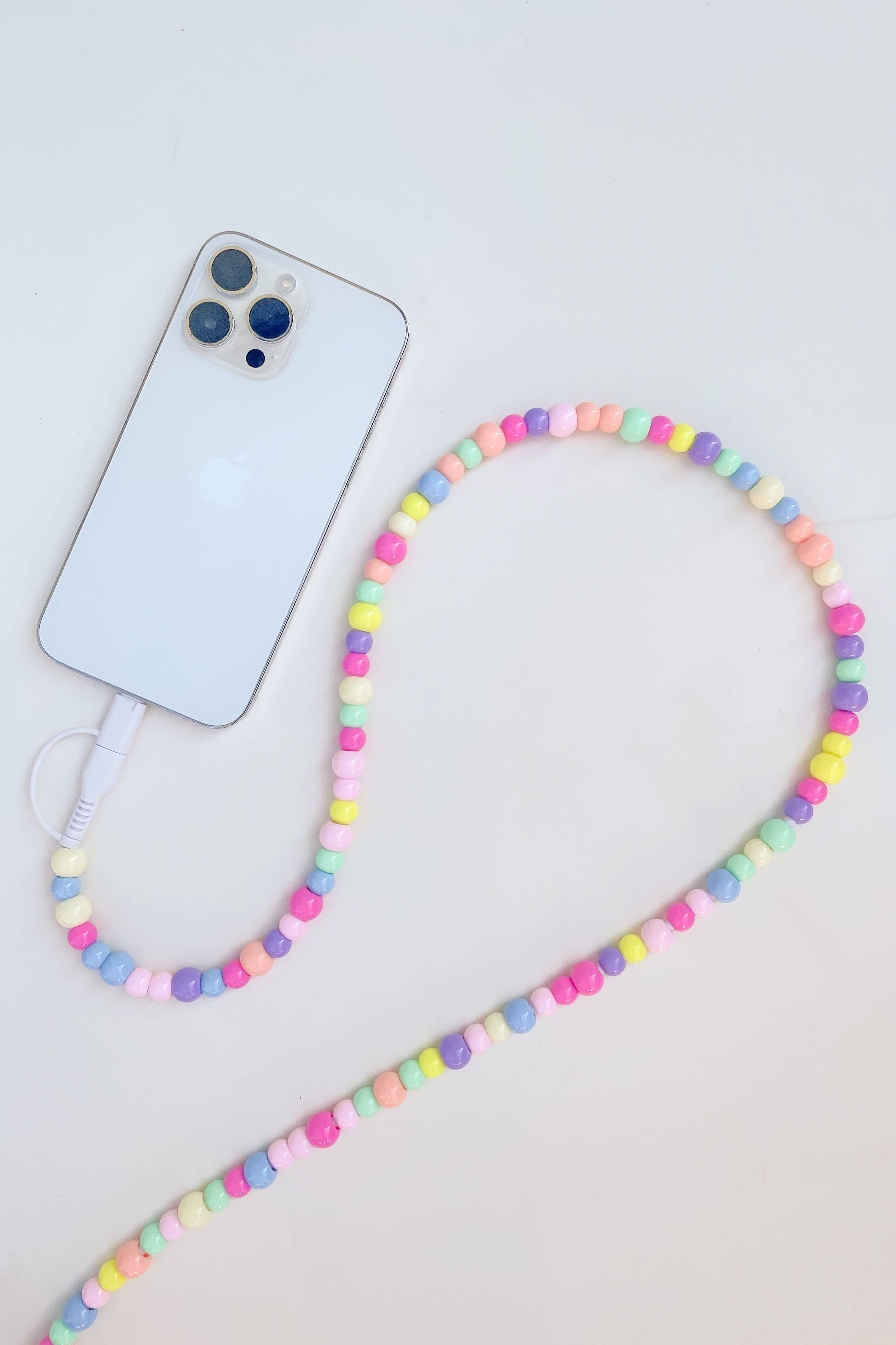 Colorful beaded phone lanyard with a smartphone on a light gray background