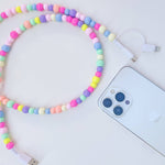 Colorful beaded phone charger next to a smartphone on a white background