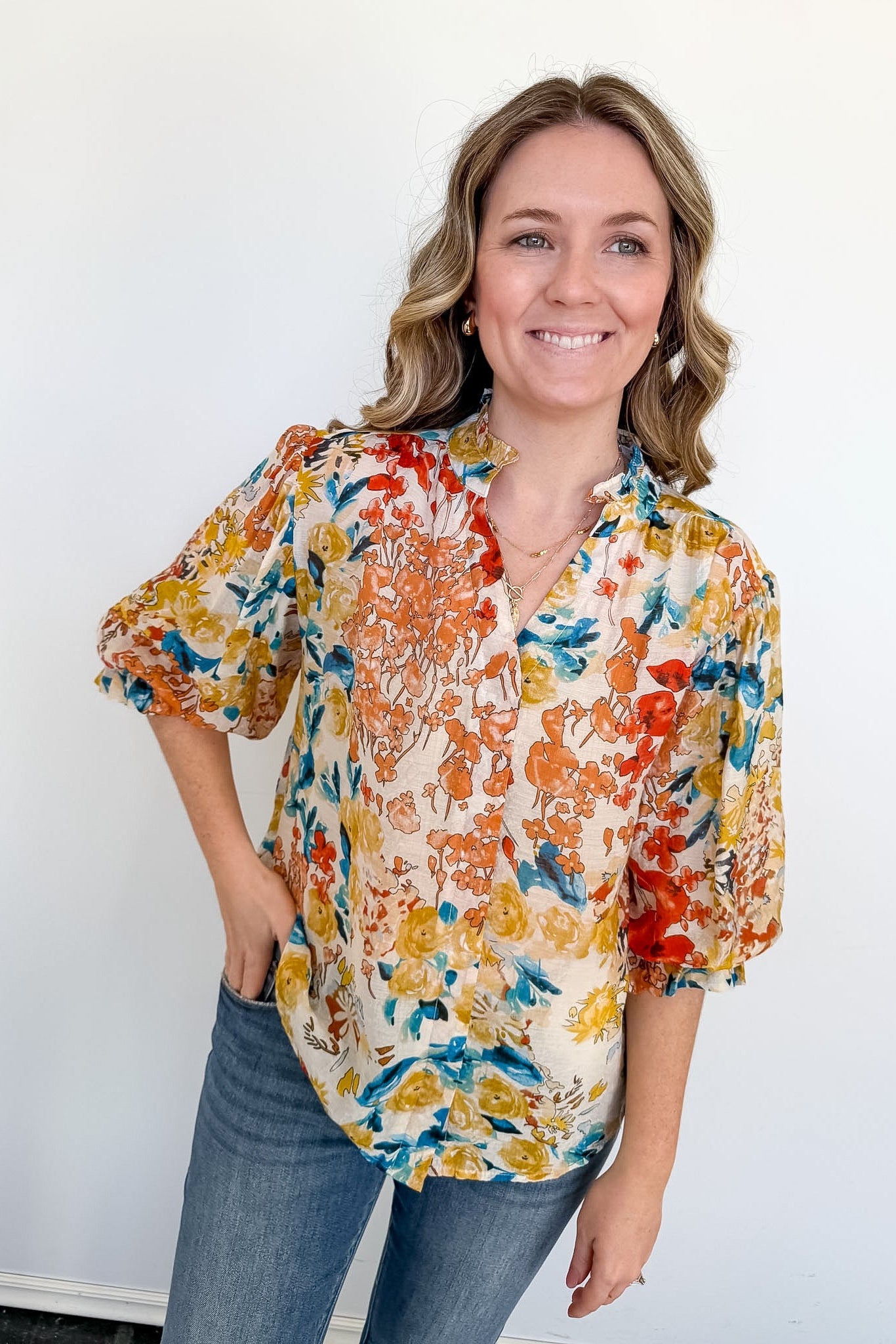 Woman wearing a colorful floral blouse against a white background