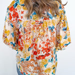 Woman wearing a colorful floral blouse with a white background