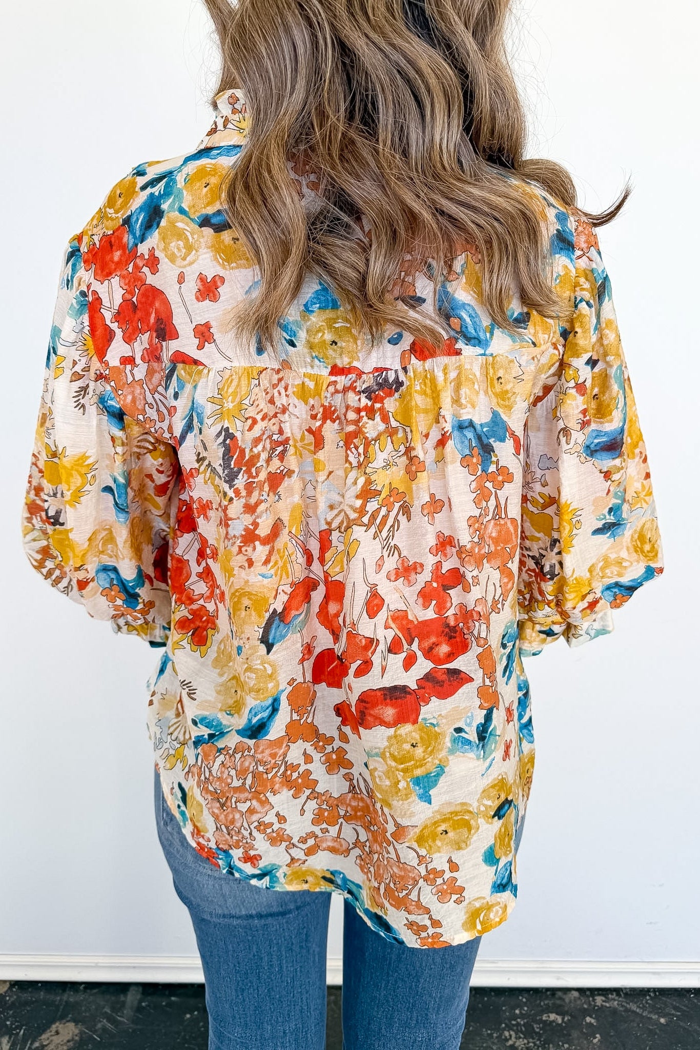 Woman wearing a colorful floral blouse with a white background