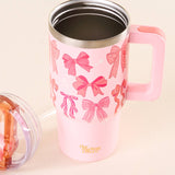 Pink tumbler with bow pattern and pink handle on a beige background