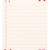 Notepad with colorful bows at the top corner on a white background