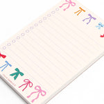 Notepad with colorful bow designs on a white background