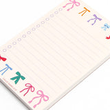 Notepad with colorful bow designs on a white background