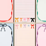 Set of six notepads with colorful bow designs on a light beige background