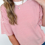 Woman wearing a red and white striped shirt with a plain background