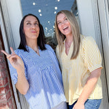 Two women standing by a door, one pointing outside.