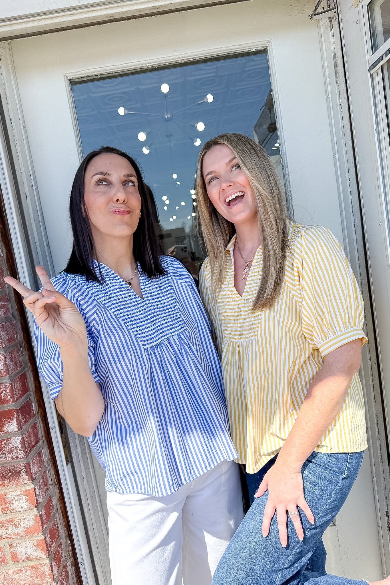 Two women standing by a door, one pointing outside.