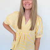 Woman wearing a yellow striped blouse against a white background