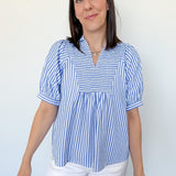 Woman wearing a blue and white striped blouse against a white background