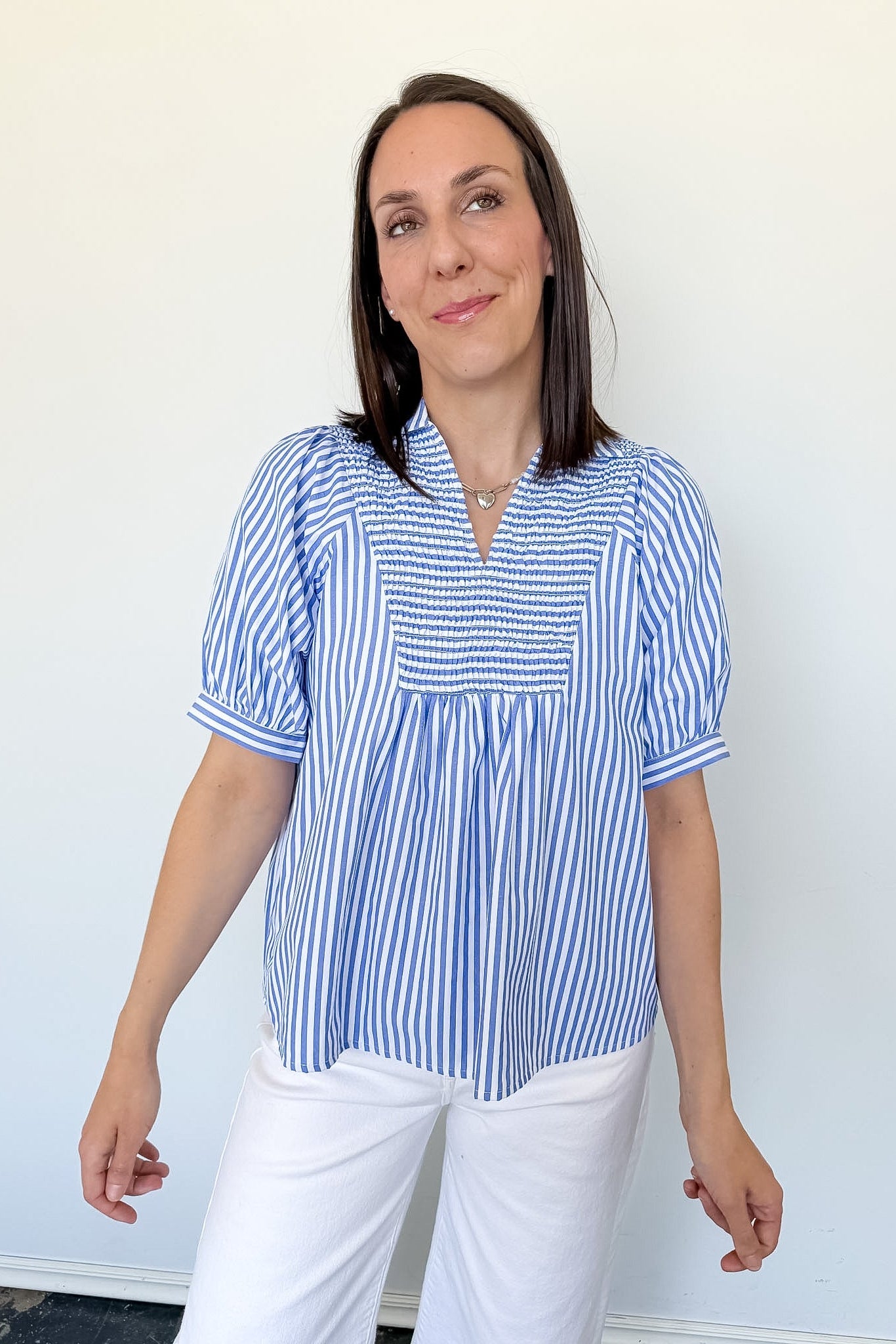 Woman wearing a blue and white striped blouse against a white background