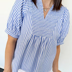 Woman wearing a blue and white striped shirt against a white background