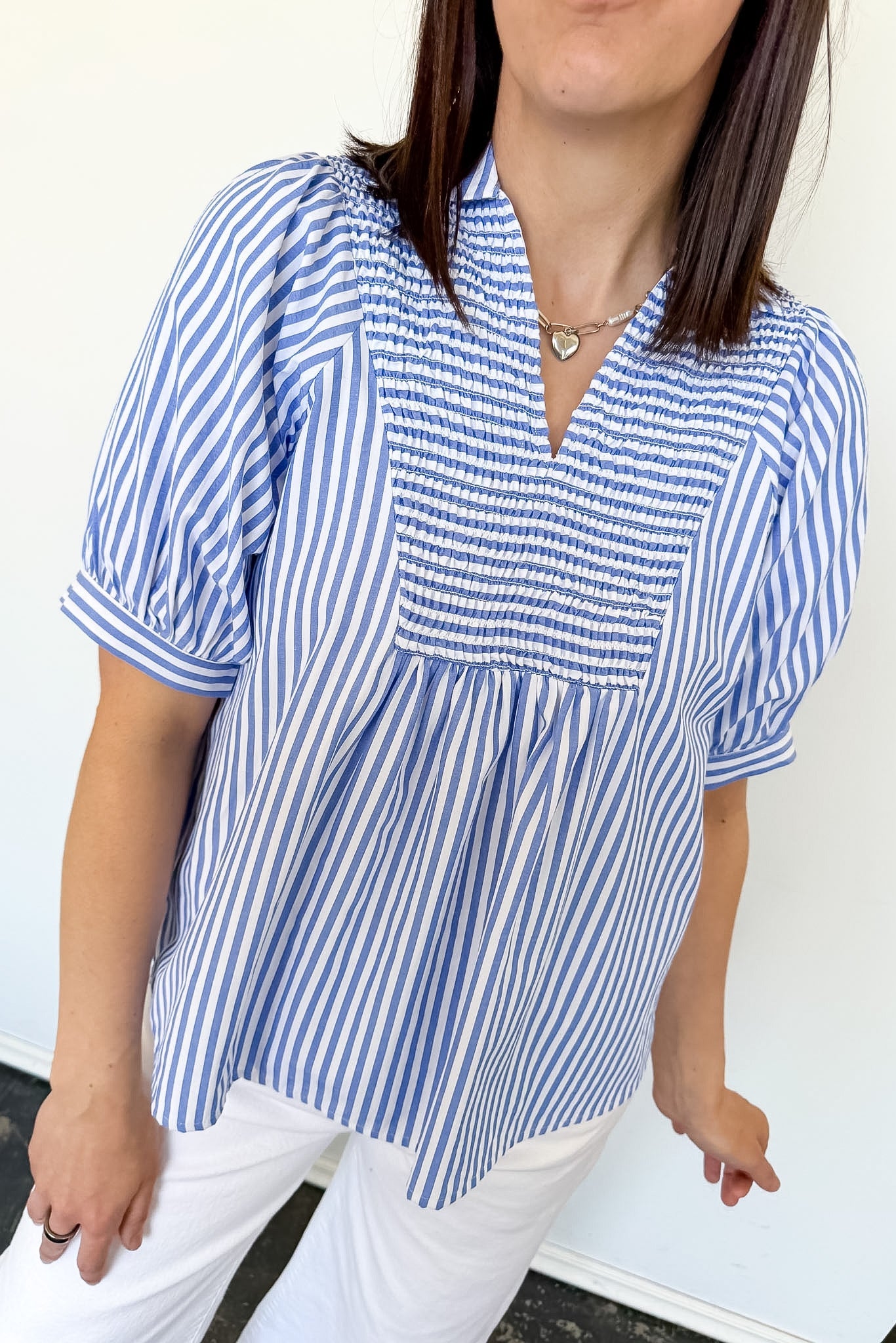 Woman wearing a blue and white striped shirt against a white background