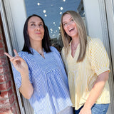 Two women standing by a door, one pointing outside.