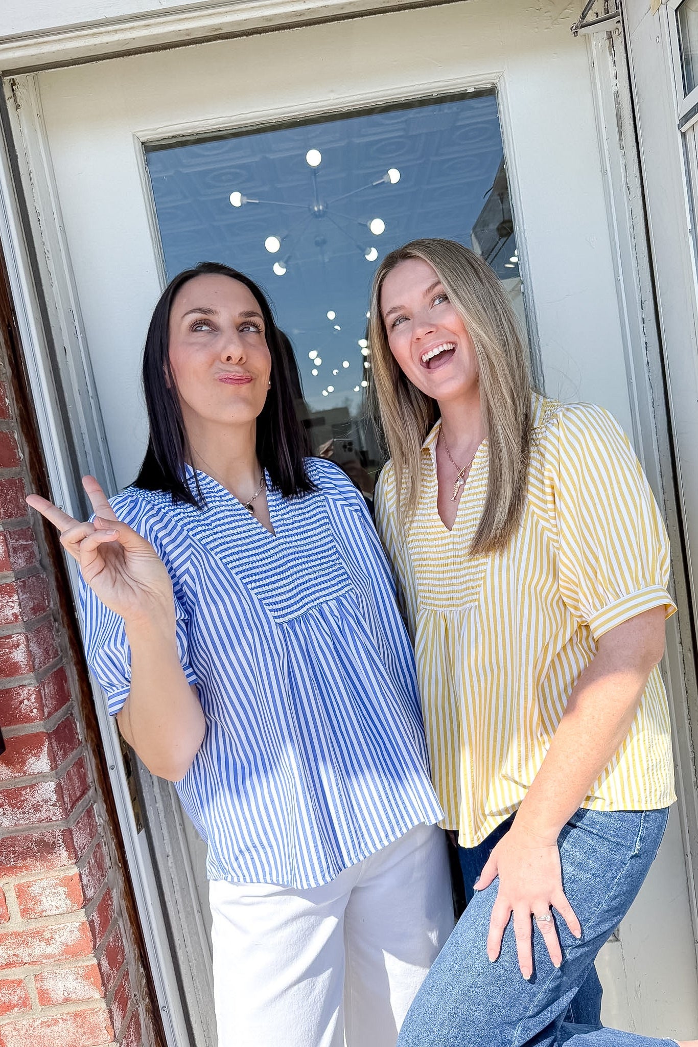 Two women standing by a door, one pointing outside.