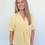 Woman wearing a yellow striped shirt against a white background