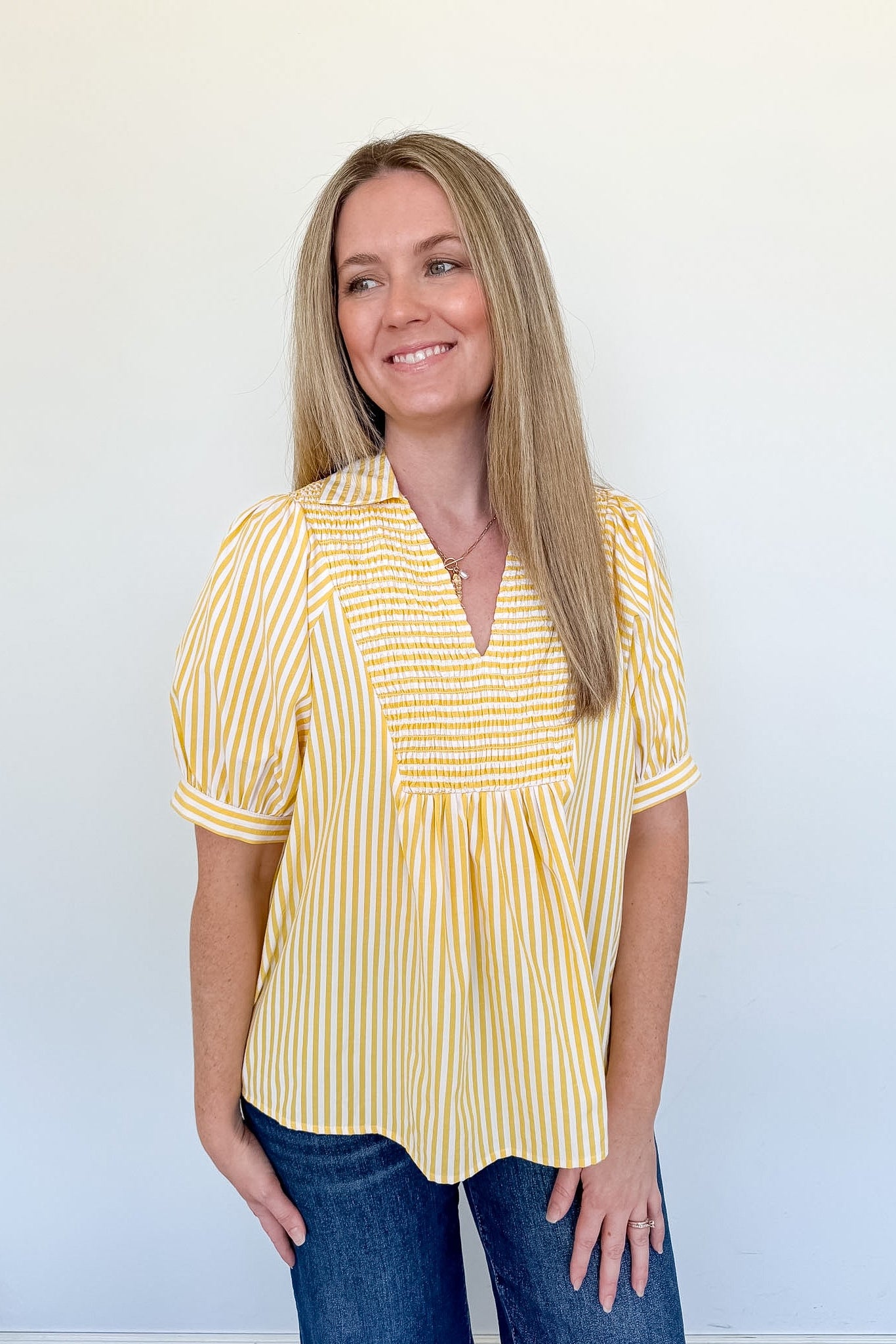 Woman wearing a yellow striped shirt against a white background