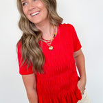 Woman wearing a red blouse with a white background
