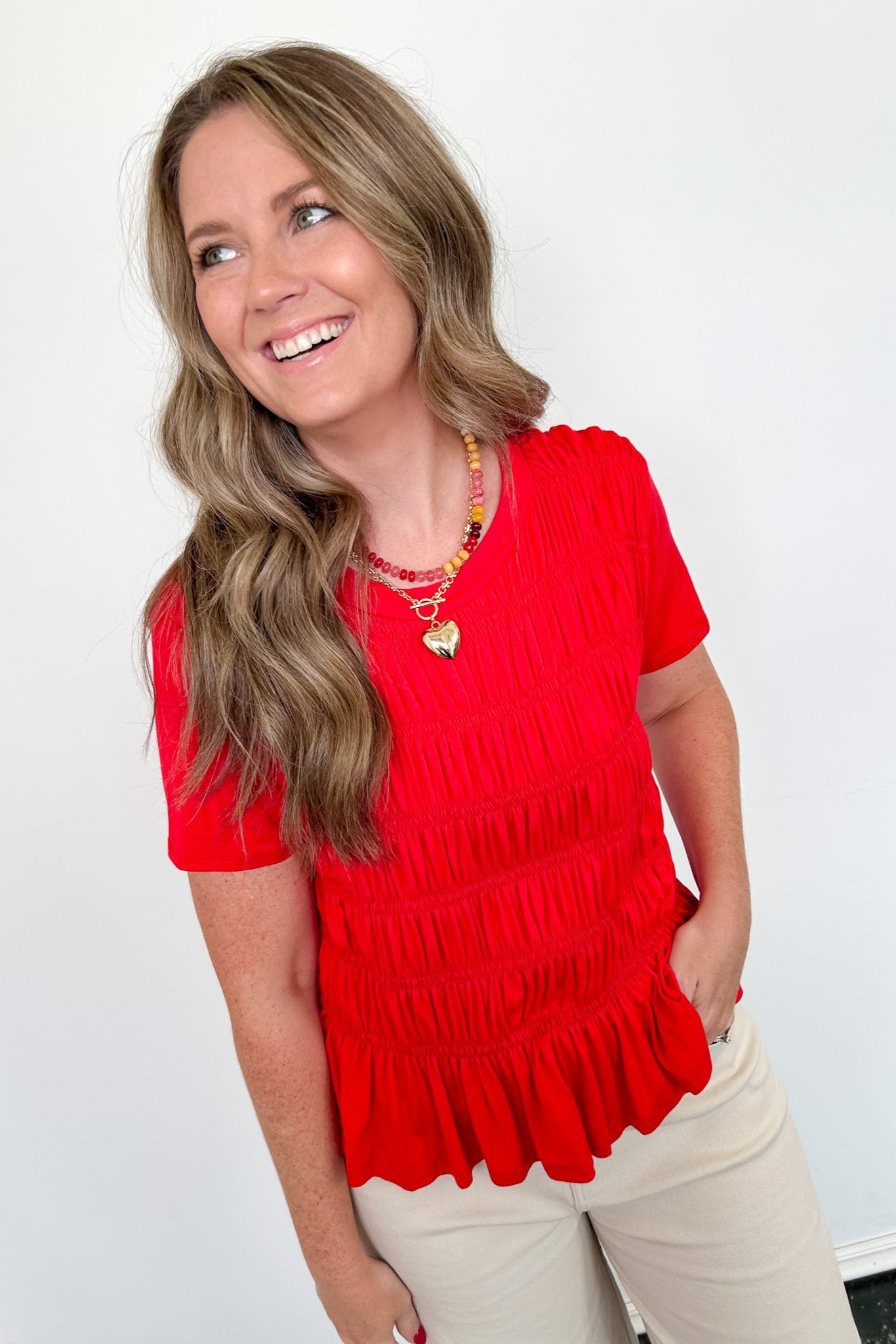 Woman wearing a red blouse with a white background